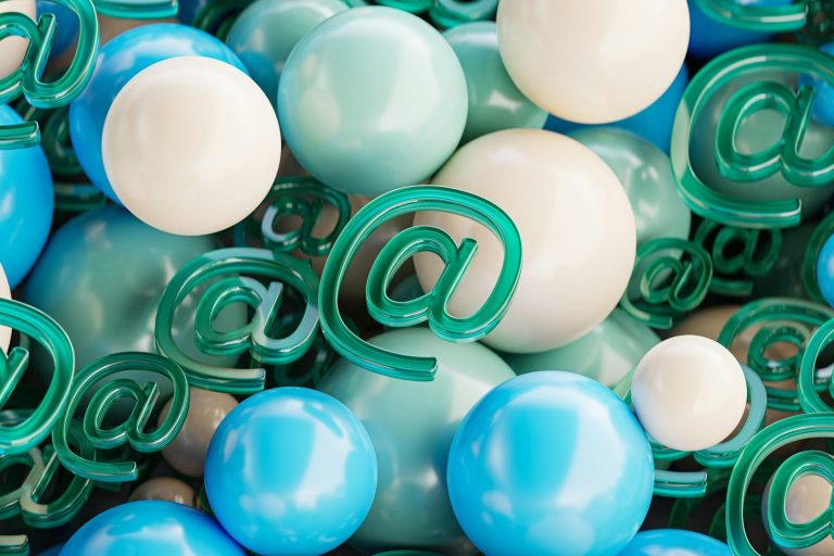 Boules colorées bleues et blanches avec des symboles arobase verts.